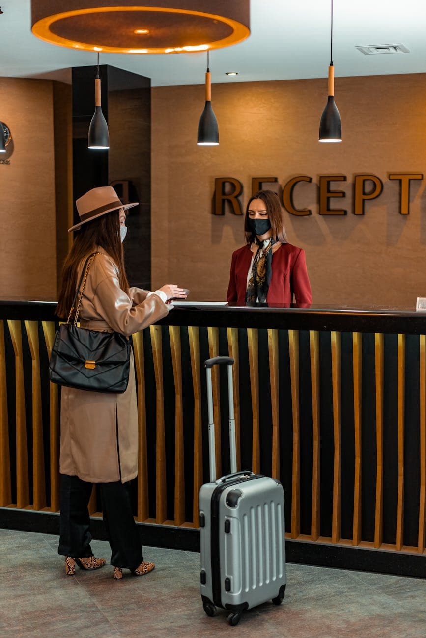 a female tourist talking to the female receptionist of the hotel