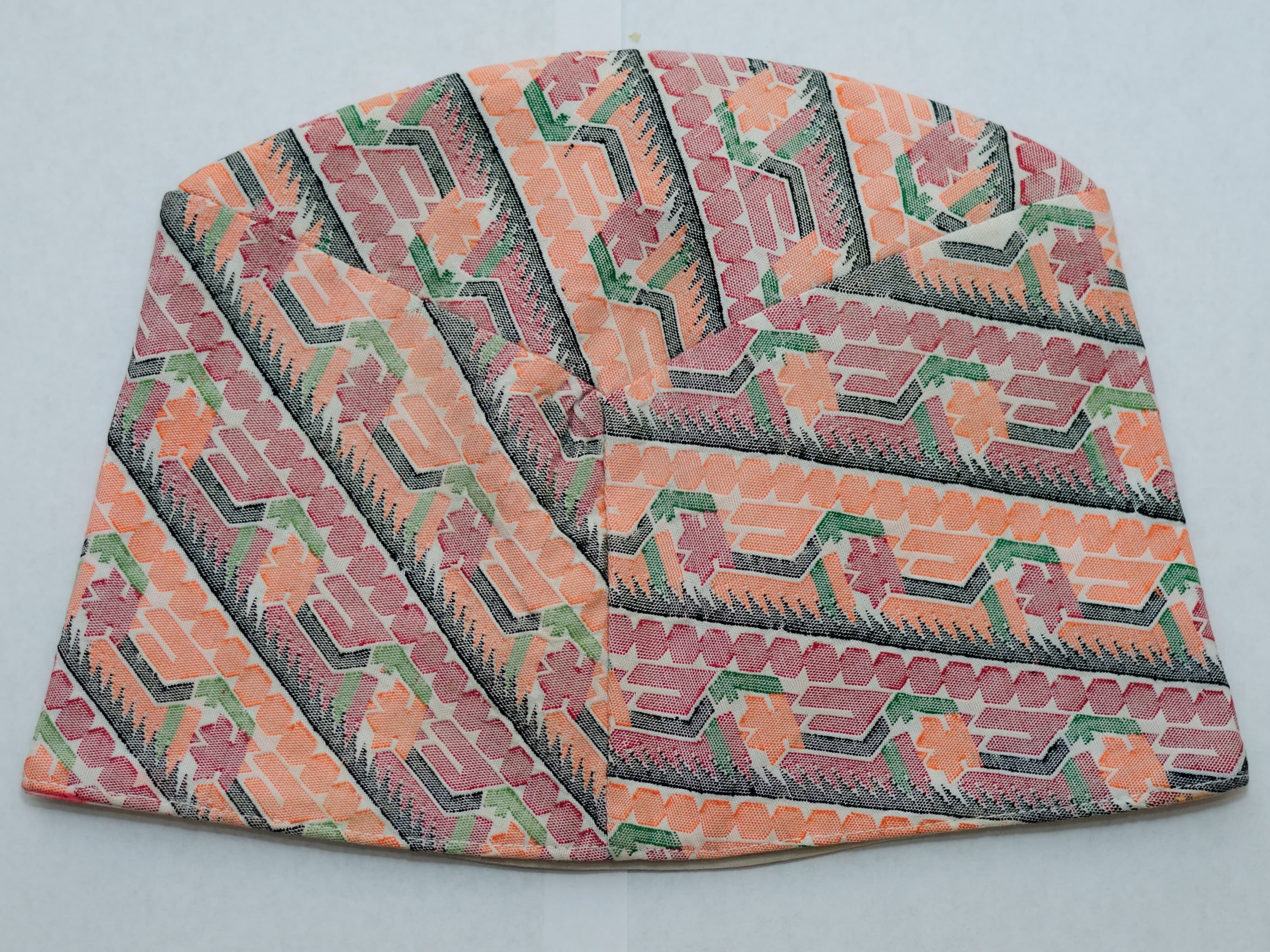 A handwoven Nepali dhaka topi showing the diamond-patterned Dhaka fabric